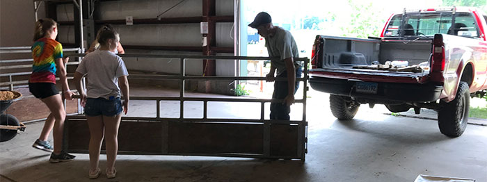 teenagers carry a heavy steel panel