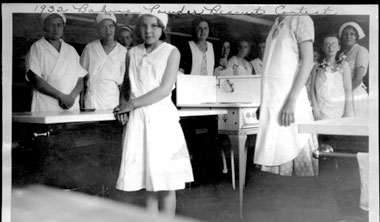 girl and ladies dressed in white around table